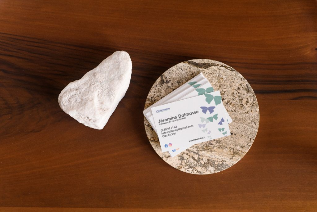 Mockuuups Business card mockup on a stone coaster with a wooden table
